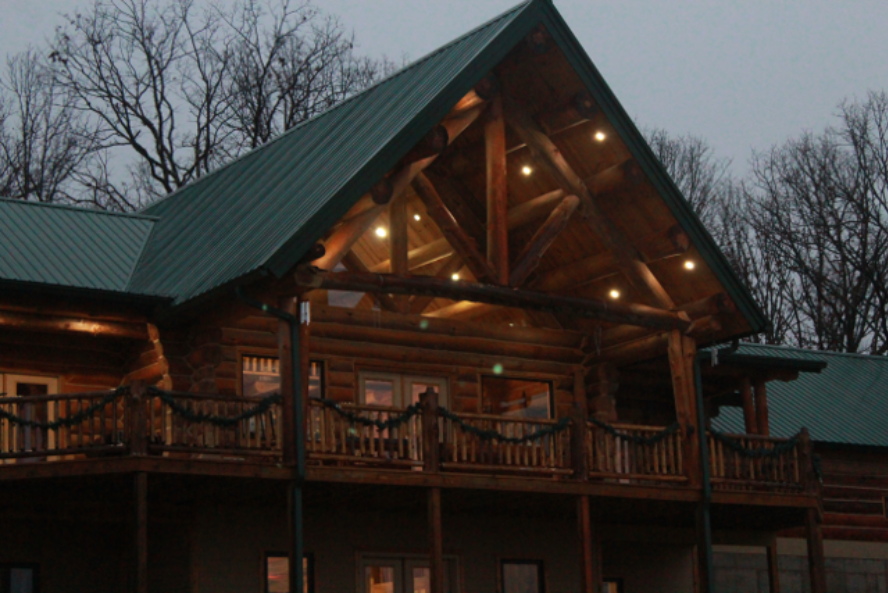 The Gordon log home at dusk with warm light behind the porch