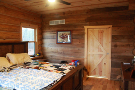 Guest bedroom under the sloped log ceiling