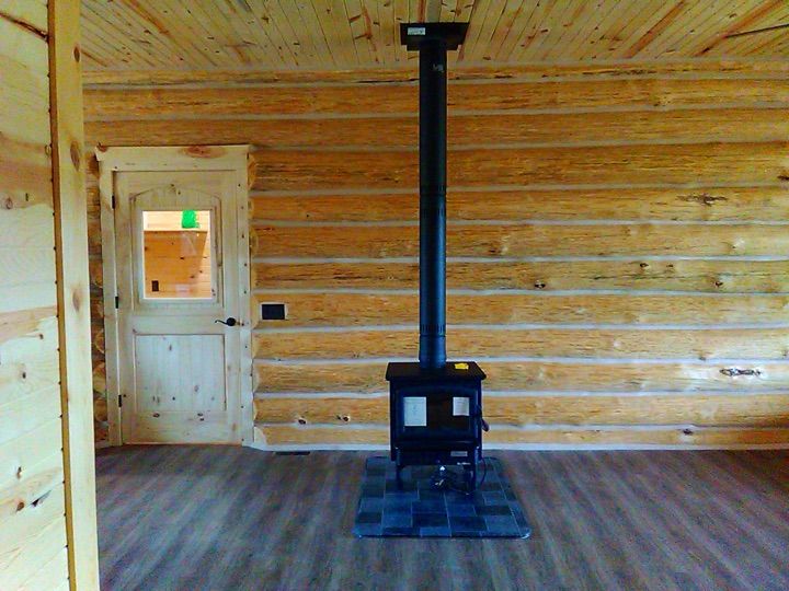 Wood stove and log wall in a nearly finished interior