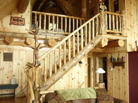 Hand-peeled log railing detail at the loft stair