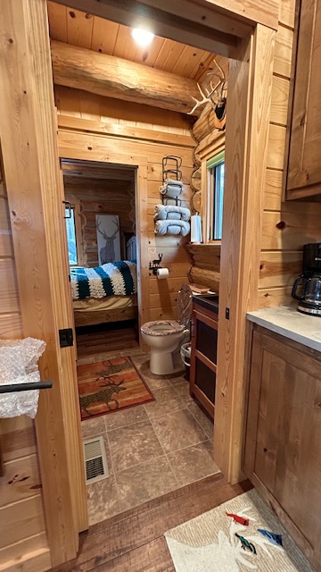 Bedroom tucked under the vaulted log ceiling