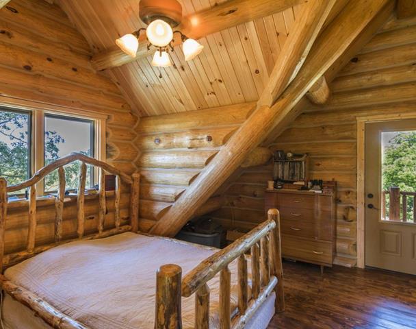 Log bed frame in the master bedroom under a vaulted ceiling