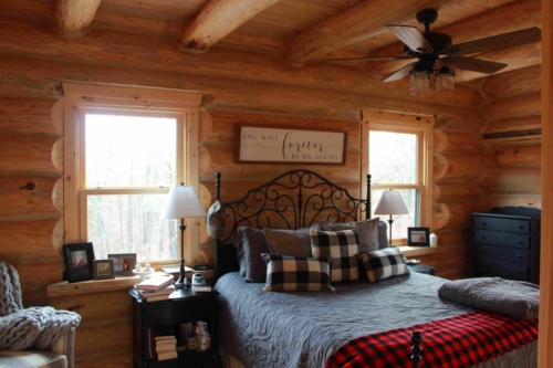 Bedroom with log walls and a rustic bed frame