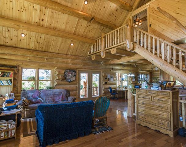 The Troyer great room with log trusses, loft overlook and window wall